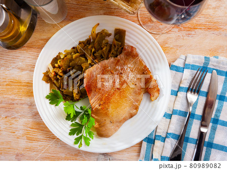 Tasty fried pork chops with stewed beans served Tasty fried pork chops with stewed beans served 80989082