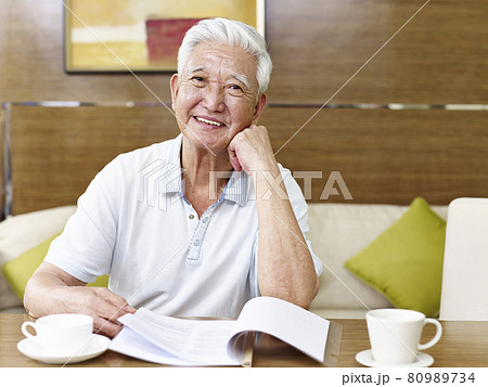 senior asian man reading a book or document in study room senior asian man reading a book or document in study room 80989734