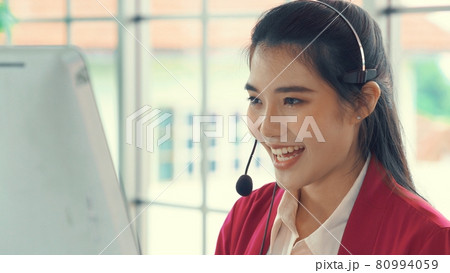 Businesswoman wearing headset working actively in office Businesswoman wearing headset working actively in office 80994059