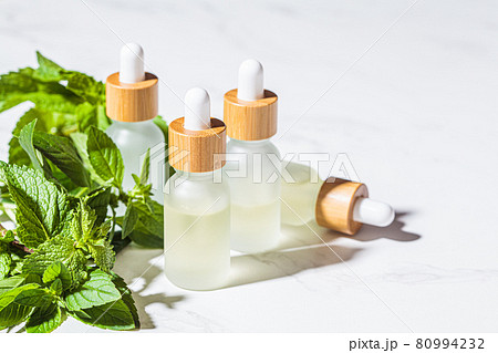 Mint essential oil in glass bottles 80994232