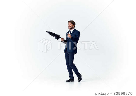 man in suit with umbrella bad weather rain light background 80999570