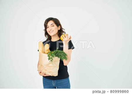 woman in a black t-shirt with a package of groceries in the hands of a delivery woman in a black t-shirt with a package of groceries in the hands of a delivery 80999860
