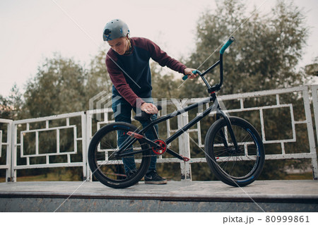 Professional young sportsman cyclist with bmx bike at skatepark. Professional young sportsman cyclist with bmx bike at skatepark. 80999861