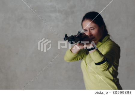 Young adult woman with rifle. Self defence concept Young adult woman with rifle. Self defence concept 80999893