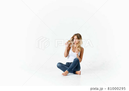 blonde in white t-shirt sitting on the floor fashion posing lifestyle blonde in white t-shirt sitting on the floor fashion posing lifestyle 81000295
