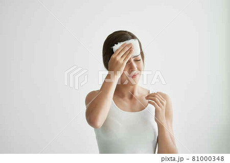 woman with headache holding headscarf on the corner migraine 81000348