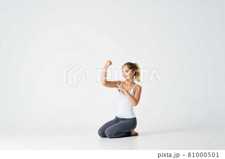 woman with dumbbells in her hands sitting on the floor exercise gym 81000501