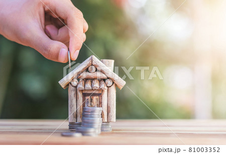 House placed on coins. hand that is coin down the house. House placed on coins. hand that is coin down the house. 81003352