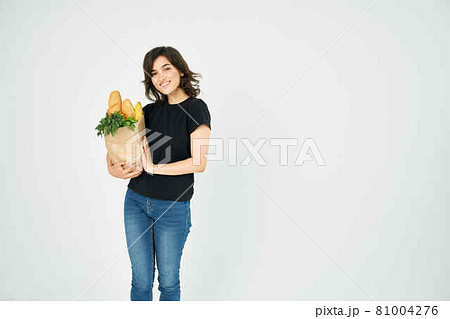 cheerful brunette with a package of groceries healthy food supermarket 81004276