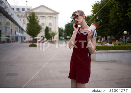 woman with short hair and a glass of coffee walking outdoors fresh air woman with short hair and a glass of coffee walking outdoors fresh air 81004277