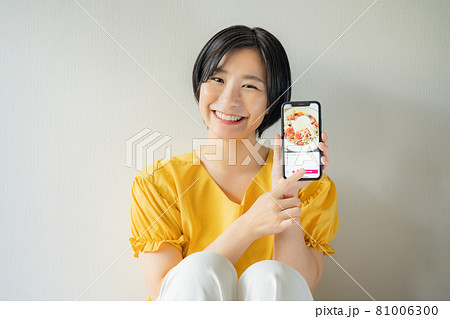 スマホでご飯を注文する女性 81006300