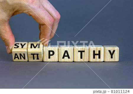 From antipathy to sympathy. Businessman turns cubes and changes the word 'antipathy' to 'sympathy'. Beautiful grey background. Copy space. Psychological and antipathy or sympathy concept. 81011124