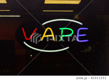 Colorful Neon Vape Sign in Rainy Smoke Shop Window, Focus on Neon Letters 81011251