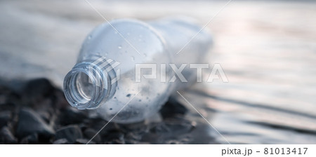 Environmental problem. Banner sea pollution garbage water trash beach. Empty bottle plastic trash lying on shore sea water waste. Discarded bottle plastic garbage sea waste ecology pollution of nature 81013417