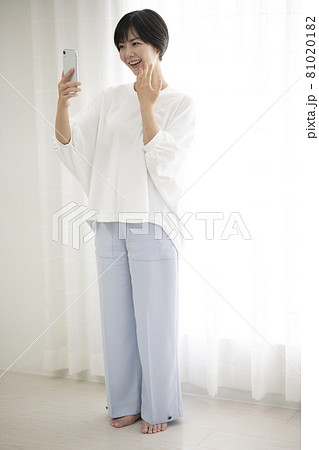 窓辺で指輪の自撮りをする女性 81020182