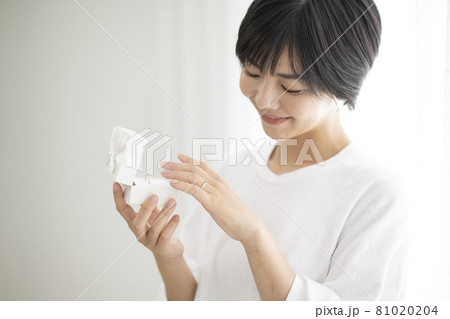 箱を開けて結婚指輪をしてみる女性 箱を開けて結婚指輪をしてみる女性 81020204