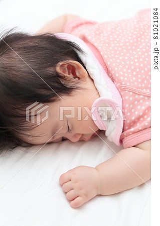 うつ伏せで寝る女の子の赤ちゃんの写真素材