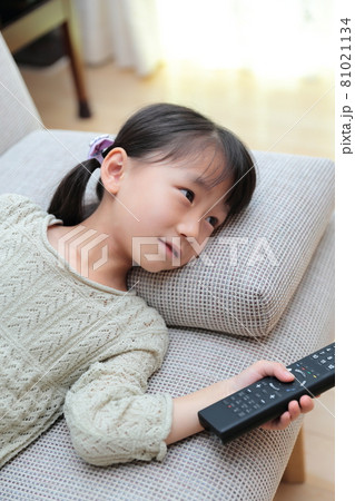ソファに寝転んでテレビを見る幼児の女の子 ソファに寝転んでテレビを見る幼児の女の子 81021134