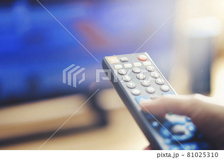 テレビのリモコンを持っている手 81025310