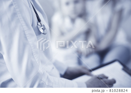 Doctor and patient. Pediatrician using clipboard while examining little girl with her mother at home. Sick and unhappy child at medical exam. Medicine concept Doctor and patient. Pediatrician using clipboard while examining little girl with her mother at home. Sick and unhappy child at medical exam. Medicine concept 81028824