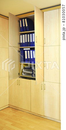 Blue and yellow files in a wooden cabinet in the modern office Blue and yellow files in a wooden cabinet in the modern office 81030057