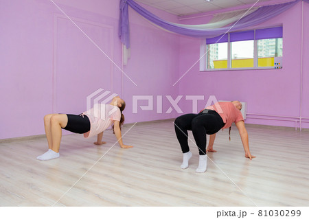 Girl dance instructor shows the elements of the number to another girl. Dance training Girl dance instructor shows the elements of the number to another girl. Dance training 81030299