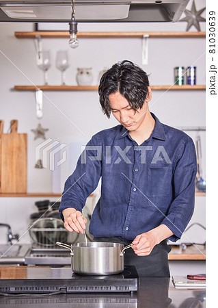 キッチンで料理するエプロン姿の若い男性 料理男子イメージ キッチンで料理するエプロン姿の若い男性 料理男子イメージ 81030639