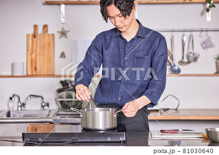 キッチンで料理するエプロン姿の若い男性 料理男子イメージ キッチンで料理するエプロン姿の若い男性 料理男子イメージ 81030640