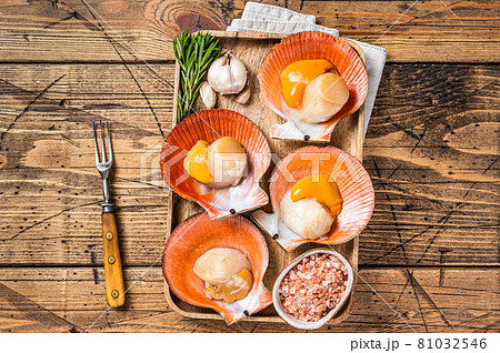 Scallops seafood on a wooden board with salt and herbs. wooden background. Top view Scallops seafood on a wooden board with salt and herbs. wooden background. Top view 81032546