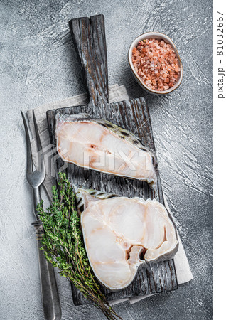 Raw wolffish fillet fish Steak on wooden cutting board. White background. Top view Raw wolffish fillet fish Steak on wooden cutting board. White background. Top view 81032667