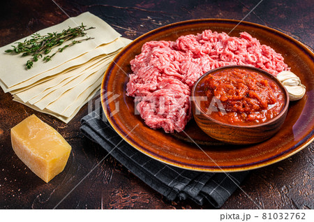Raw lasagna ingredients and products for pasta. Dark background. Top view Raw lasagna ingredients and products for pasta. Dark background. Top view 81032762