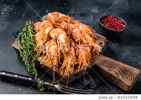 Cooked Greenland Prawn Shrimp on a wooden board. Black background. Top view 81032949