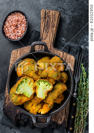 Roasted Crumbed broccoli in a pan. Black background. Top view 81032950