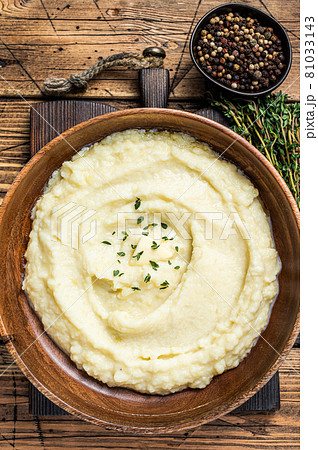 Mashed potatoes, boiled puree in a wooden plate. Wooden background. Top view 81033143