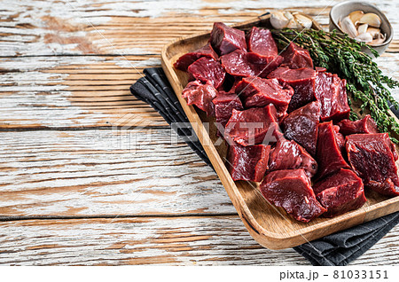 Raw sliced Beef or veal heart in a wooden tray with thyme. White wooden background. Top View. Copy space Raw sliced Beef or veal heart in a wooden tray with thyme. White wooden background. Top View. Copy space 81033151