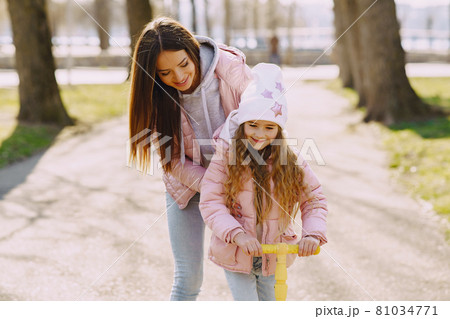 Mother with daughter in a spring park with skate Mother with daughter in a spring park with skate 81034771