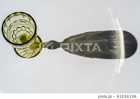 Green glass goblet . Abstract shadow pattern on white background Green glass goblet . Abstract shadow pattern on white background 81036196