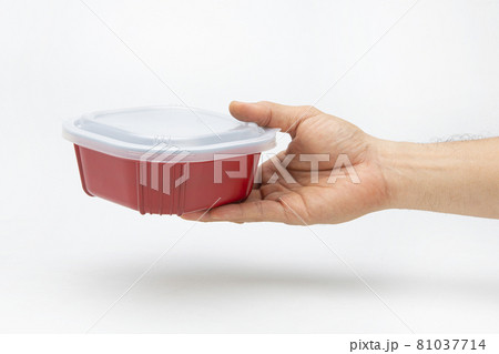 A plastic box in hand for holding food on a white background A plastic box in hand for holding food on a white background 81037714