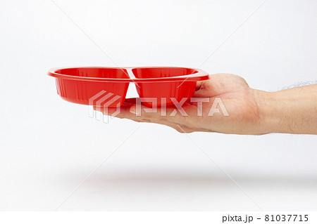 A plastic box in hand for holding food on a white background A plastic box in hand for holding food on a white background 81037715