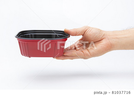 A plastic box in hand for holding food on a white background A plastic box in hand for holding food on a white background 81037716