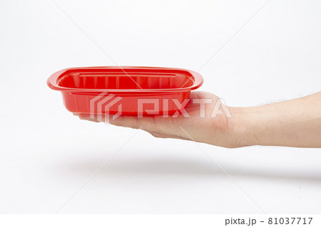 A plastic box in hand for holding food on a white background A plastic box in hand for holding food on a white background 81037717