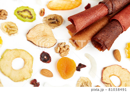 Neatly stacked fruit lozenge different colors and nuts.  81038491