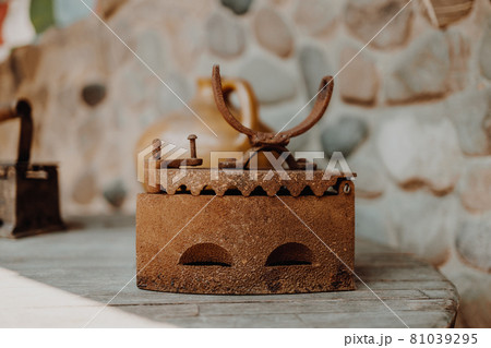 Close up of an antique and rusty iron on wood table background. Houseworks. 81039295