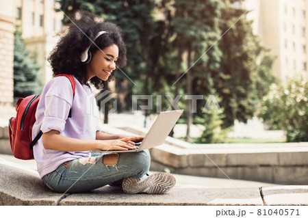 African American Female Student Using Laptop Learning Sitting Outdoor African American Female Student Using Laptop Learning Sitting Outdoor 81040571