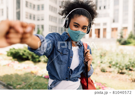 Black Student Girl Wearing Mask Bumping Fists With Classmate Outdoors Black Student Girl Wearing Mask Bumping Fists With Classmate Outdoors 81040572