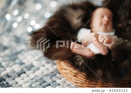 image of a newborn baby sleeping in a baby basket . 81043132