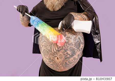 Fat man in hero suit sprays detergent onto brush on purple background 81043907