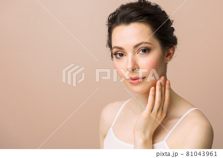 Young beautiful woman with perfect skin, touching her face. Cosmetology, beauty and spa concept. 81043961