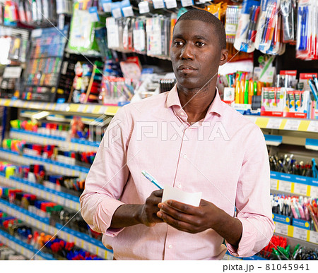Portrait of Afro American man choosing ball pen at stationery store Portrait of Afro American man choosing ball pen at stationery store 81045941