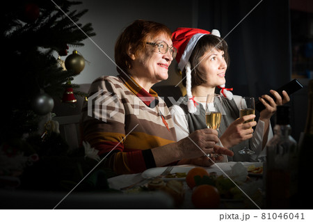 Women watching Christmas tv program Women watching Christmas tv program 81046041